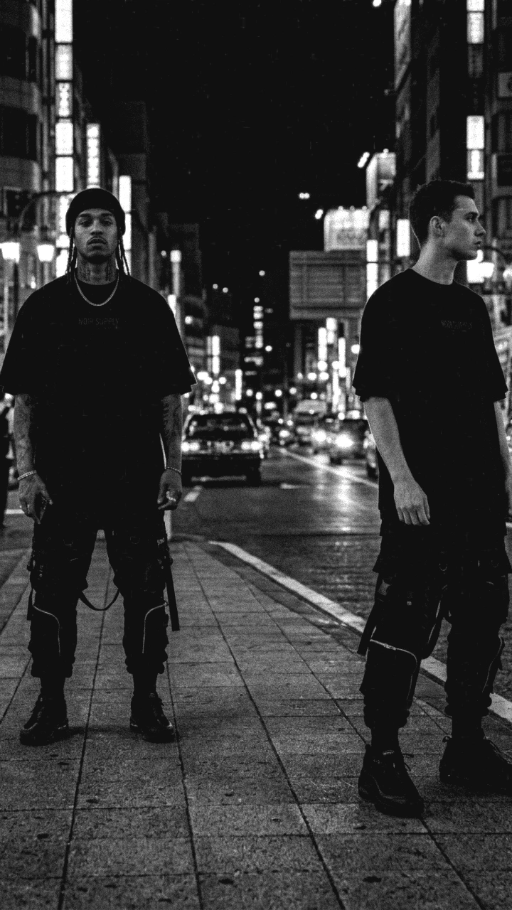 Dupla streetwear NOIR SUPPLY em cenário urbano noturno